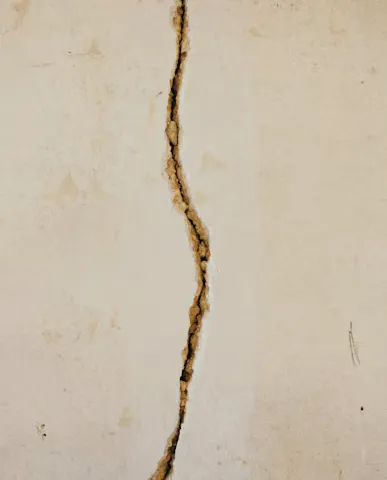 A narrow crack running through a pale concrete surface