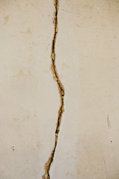 A narrow crack running through a pale concrete surface