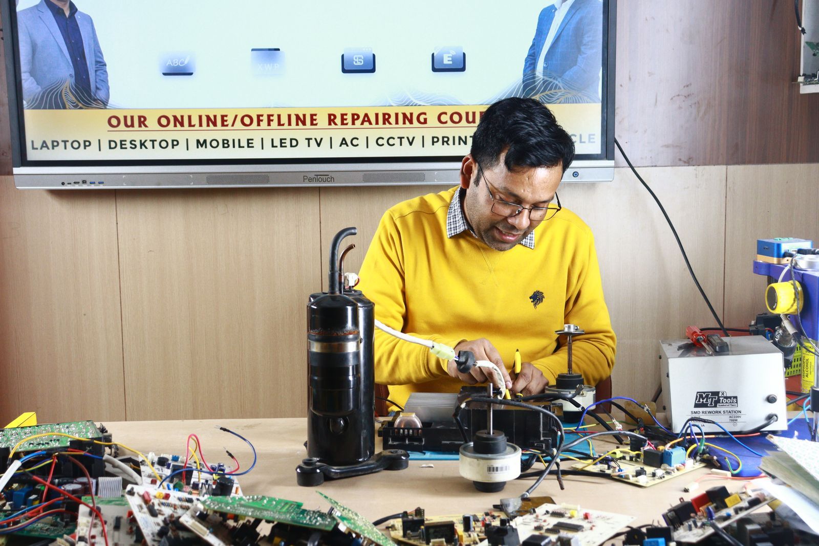 Técnico reparando la placa electrónica de un aire acondicionado en un banco de trabajo