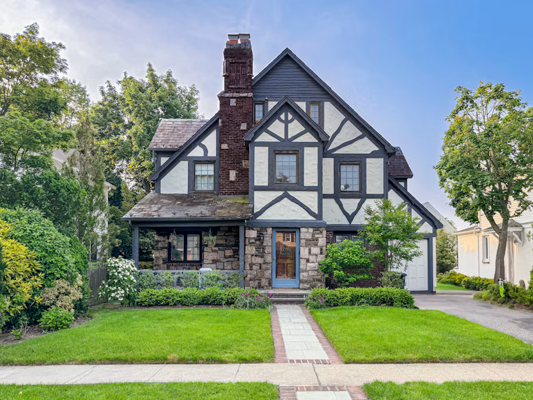 A detached home with a green front lawn and mature trees