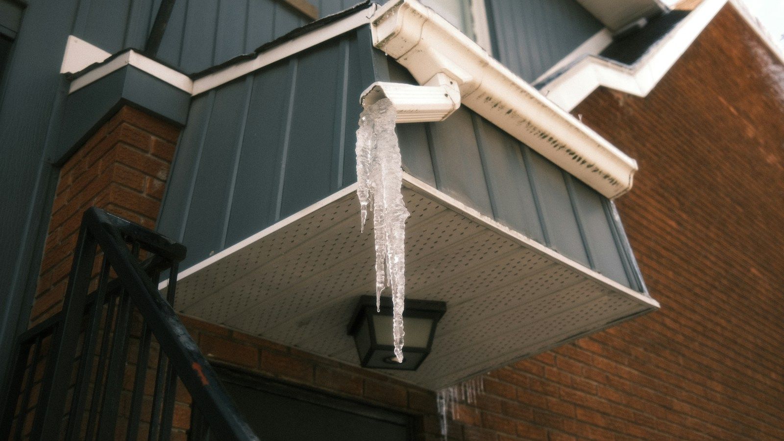 Icicles hanging from a white gutter on a house